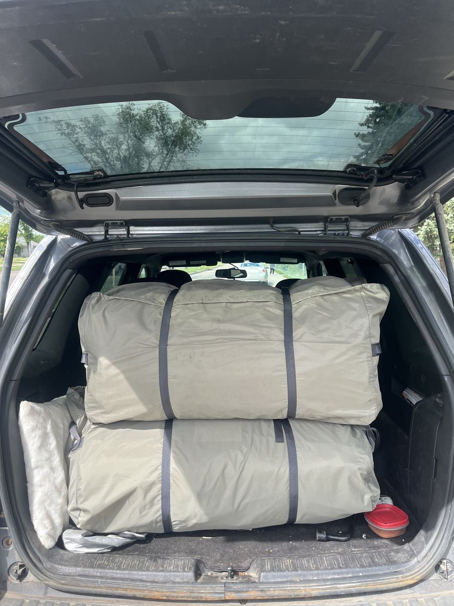 K1 Outdoors tent packed into duffel bags in the back of a Ford Escape, ready for pickup
