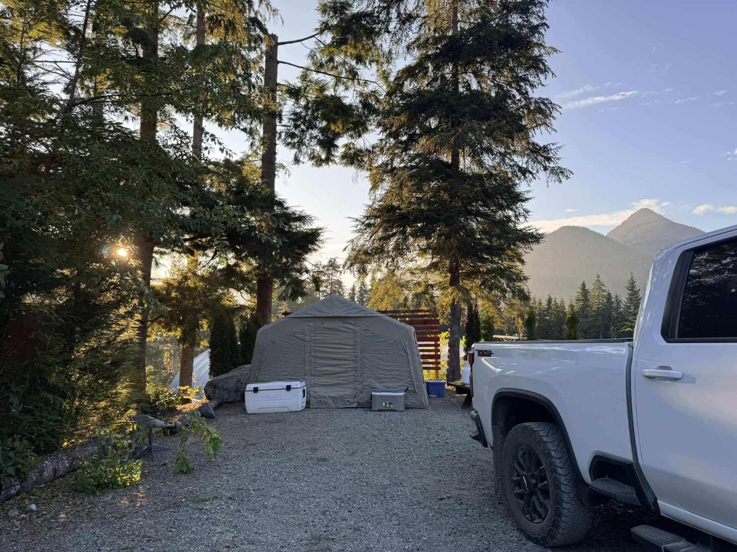 K1 Outdoors tent set up at a forest campsite at sunset